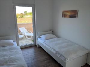 een kleine slaapkamer met een bed en een balkon bij Ferienwohnung in Nin mit Großer Terrasse in Nin