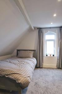 un dormitorio con una cama y una ventana en Castle Manor, 4 Bed Seaside Retreat, en Scarborough