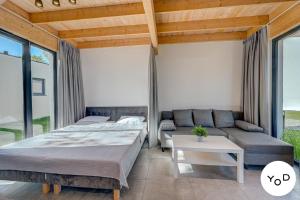 a bedroom with two beds and a couch at Nettes Ferienhaus in Pustkowo mit Eigener Terrasse in Pustkowo