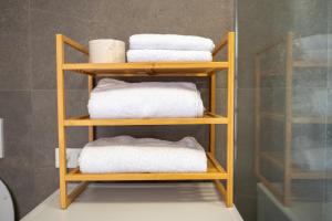 un juego de cuatro toallas en un estante en un baño en Apartments Luxury AD en Jesenice