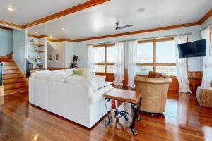 een woonkamer met een witte bank en een tv bij Hello Sunshine in St. George Island