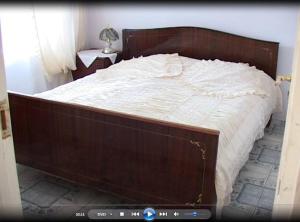 a bed with a wooden frame in a bedroom at Anna Maria Hotel in Alaverdi