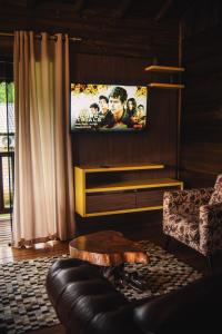 a living room with a flat screen tv on a wall at Pousada Equilíbrio dos Canyons in Praia Grande