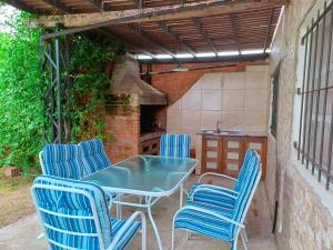 a patio with blue chairs and a table and a kitchen at Villawolf Casa para 5 personas in Federación