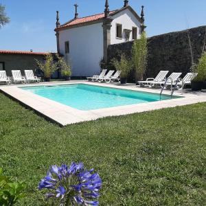 uma piscina num quintal com cadeiras e uma casa em 3 bedrooms house with shared pool enclosed garden and wifi at Covelas Povoa de Lanhoso em Póvoa de Lanhoso