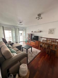 a living room with a couch and a dining room at Vivienda vacacional: Los Abuelos in San Vicente de la Barquera