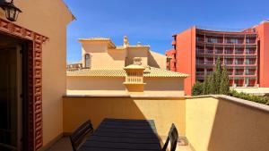 a balcony with a table and chairs and a building at Bicos 303 - Shared Pool - 6 Guests - Albufeira in Albufeira