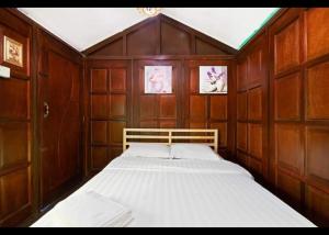 a bedroom with wooden walls and a bed in it at Hillside cottage tanah rata in Tanah Rata