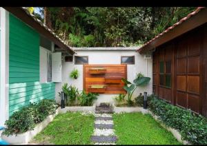 a house with a wooden door and a yard at Hillside cottage tanah rata in Tanah Rata +17 photos