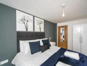 a bedroom with a large bed with blue and white pillows at Lovely studio apartment in Slough