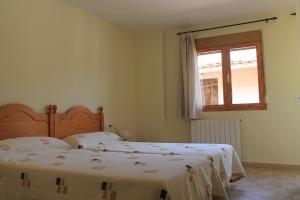 a bedroom with two beds and a window at Apartamentos Turísticos Rosario in Camarena de la Sierra