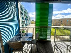 a balcony with a table and chairs and a building at Blueberry Tree Apartment in Cambridge