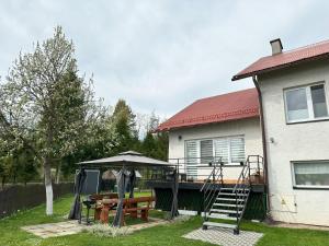 een huis met een speeltuin met een tafel en een schommel bij Na Zielonym Szlaku in Ustrzyki Dolne