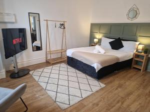 a bedroom with a bed and a flat screen tv at West Beck House - Newcastle 3 in North Shields