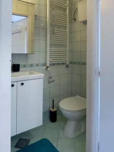a white bathroom with a toilet and a sink at Lotus - Designer apt in city center in Zagreb