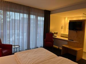 a hotel room with a bed and a television at Villavelo Twente in Ootmarsum