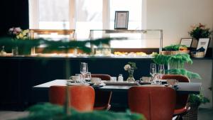 stół w restauracji z krzesłami i stół z okularami w obiekcie Loft Hotel Rauma w mieście Rauma