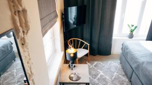 a room with a bed and a tv and a chair at Loft Hotel Rauma - huonekohtaisella ilmastoinnilla in Rauma