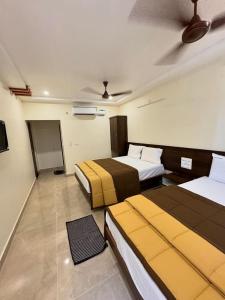 a hotel room with two beds and a fan at HOTEL DKR GRAND in Tirupati