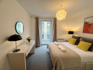 a bedroom with two beds and a table and a mirror at Blueberry Tree Apartment in Cambridge