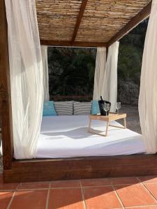 a canopy bed with a white mattress and a table at Casa Luna in La Drova