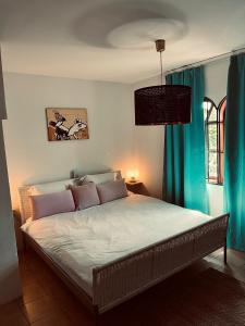 um quarto com uma cama grande e cortinas azuis em Casa Leonore Studio em Willemstad
