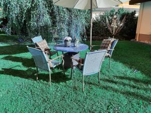 Ferienwohnung Idyll mit Loggia und Garten في Welferode: طاولة وكراسي يجلسون تحت مظلة في ساحة