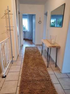 a hallway with a table and a rug on the floor at Ferienwohnung Idyll mit Loggia und Garten in Welferode