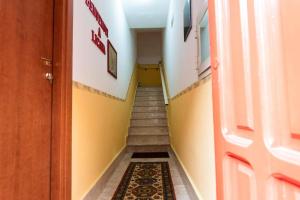 um corredor com uma escada com paredes amarelas e uma porta em La dimora del monsignore em Licata