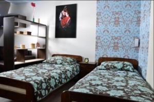 キェルツェにあるApartament Kielce Folkの青い壁紙のベッドルーム1室(ベッド2台付)