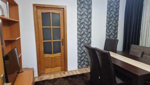 ドロベタ・トゥルヌ・セヴェリンにあるApartament Alinaの木製のドア、テーブルと椅子が備わる客室です。