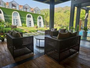 a patio with chairs and a table and a green wall at NYAST VALLEY RESORT, ARPORA in Arpora