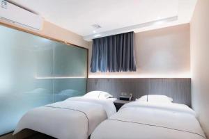 duas camas sentadas uma ao lado da outra num quarto em Guangzhou Haiyue Hotel em Guangzhou
