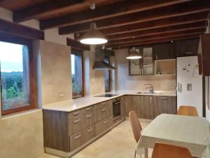 a kitchen with wooden cabinets and a table with a dining room at Alcabala del Viento in Noriega