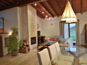 a living room with a glass table and a chandelier at Alcabala del Viento in Noriega