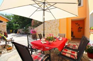 een tafel met een witte parasol op een patio bij Ferienwohnung für 6 Personen ca 75 qm in Krnica, Istrien Bucht von Raša in Krnica