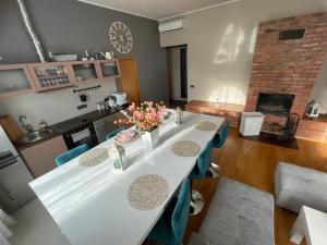 a dining room with a white table and blue chairs at Kunderi apartment with sauna in Rakvere