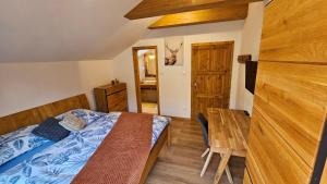 Schlafzimmer mit einem Bett und einem Holztisch in der Unterkunft Chalet Robinson in Modra