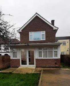 a brick house with a large window on it at Romford Lodge in Romford