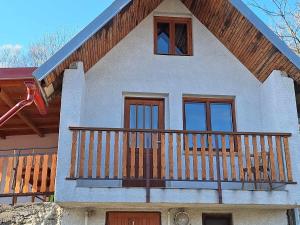 a house with a balcony with a wooden railing at Chata u poľovníka in Nová Sedlica