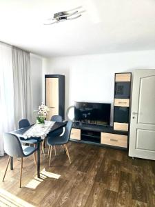 a dining room with a table and chairs and a television at Apartament Lily in Alba Iulia