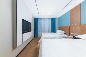 um quarto de hotel com duas camas e uma televisão em Guangzhou Haiyue Hotel em Guangzhou