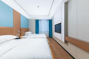 a bedroom with two beds and a television at Guangzhou Haiyue Hotel in Guangzhou