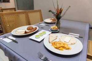 a blue table with plates of food on it at Hotel Alcaravan Medellín in Medellín