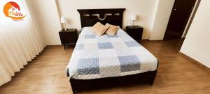 1 dormitorio con 1 cama con edredón azul y blanco en NatAle Residencial - Departamento Segundo Piso con cochera, en Tacna