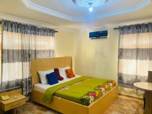 1 dormitorio con 1 cama en una habitación con cortinas en Legends Castle Suites, en Gwarinpa