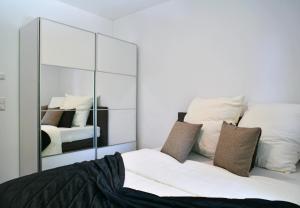 um quarto com um espelho e uma cama em Appartement im Grünen, zentral in Biberach em Biberach an der Riß