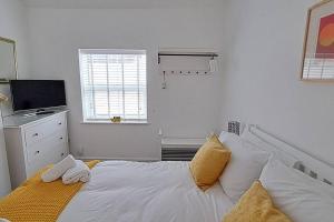 een witte slaapkamer met een bed en een raam bij The Tanners Cottage in Hathern