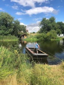 een man op een boot in het water bij The Tanners Cottage in Hathern