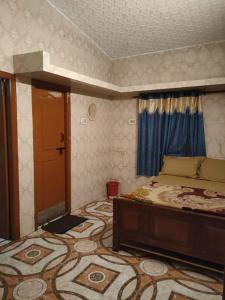 ein Schlafzimmer mit einem Bett und einem großen Teppich in der Unterkunft TRIOS in Udagamandalam